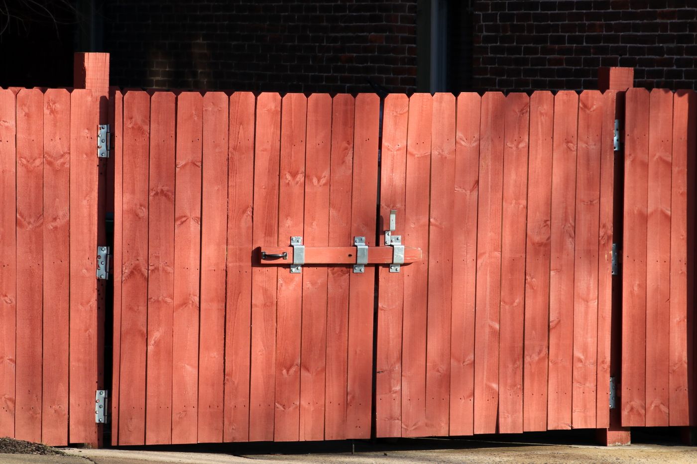 Wood privacy fence with double gate installed along a residential property